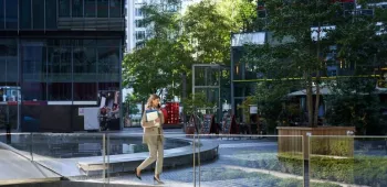 Environnement tertiaire et espaces extérieurs aménagés Employée marchant dans un espace extérieur aménagé entre plusieurs immeubles de bureaux